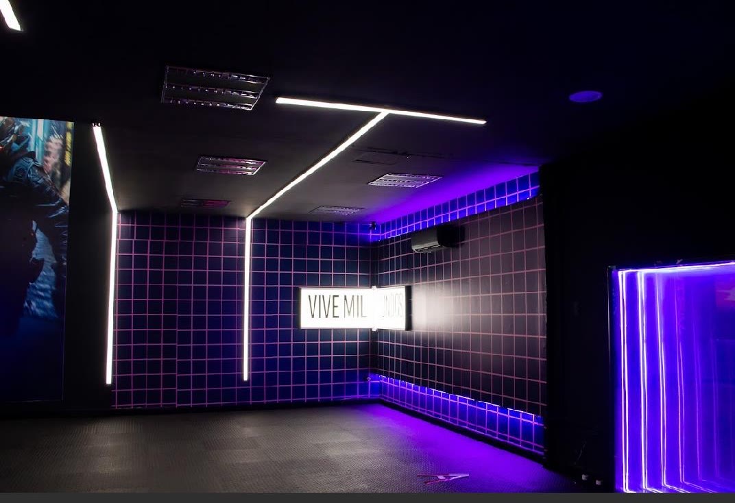 Arena con muros de cuadrícula rosa y letrero Vive mil mundos